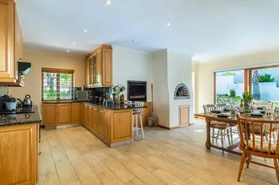 a large kitchen with wooden cabinets and a table at Sea 'n Summit Hermanus in Hermanus