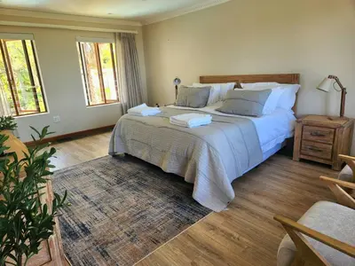 a bedroom with a large white bed and a rug at Sea 'n Summit Hermanus in Hermanus