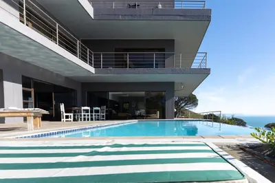 a swimming pool in front of a house at Gordons Bay Villa with Pool in Gordonʼs Bay