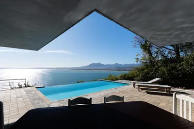 a swimming pool with a view of the water at Gordons Bay Villa with Pool in Gordonʼs Bay