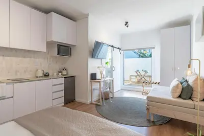a kitchen and living room with white cabinets and a couch at 107 Dorpstraat Boutique Hotel in Stellenbosch