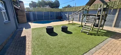 a backyard with a yard with a ladder and some grass at Murray Guest Suite in Goodwood
