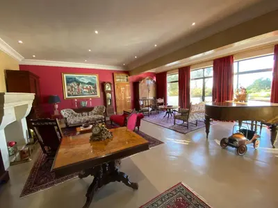 a living room with red walls and a grand piano at The Welgemoed Guest House in Bellville