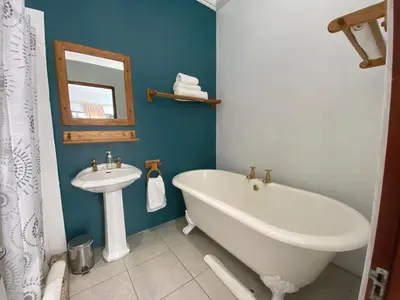 a bathroom with a white tub and a sink at The Welgemoed Guest House in Bellville