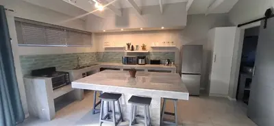 a kitchen with a large island in the middle at Kiewiets Nest in Victory Hill