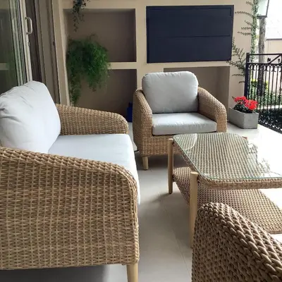 a patio with wicker chairs and a tv on a porch at Apartment Franschhoek 121 Lermitage in Franschhoek