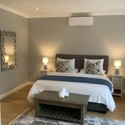 a bedroom with a large bed and two lamps at Apartment Franschhoek 121 Lermitage in Franschhoek