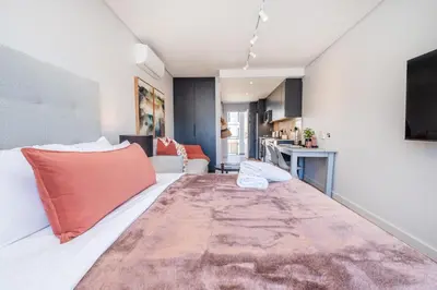 a room with a large white bed with red pillows at 136 Paarl Studio With Onsite Parking Comforts in Paarl