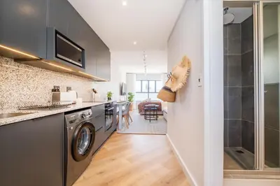 a kitchen with a washing machine and a dining room at 136 Paarl Studio With Onsite Parking Comforts in Paarl