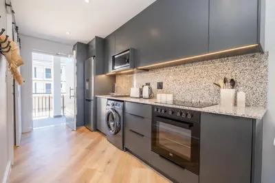 a kitchen with a stove and a washer and dryer at 136 Paarl Studio With Onsite Parking Comforts in Paarl