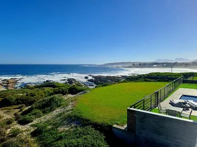 a house with a view of the ocean at Spacious 4 Bedroom on the Beach in Hermanus