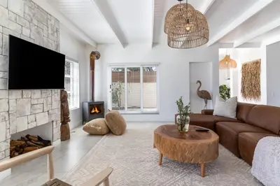a living room with a couch and a fireplace at Luxury Flamingo Villa at beach with Pool and Solar Back Up in Cape Town