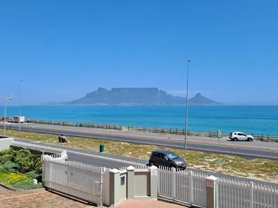 a car driving down a road next to the ocean at Aandvari Zeezicht in Cape Town