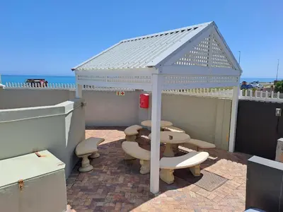 a gazebo with benches and tables on a patio at Aandvari Zeezicht in Cape Town