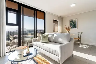 a living room with a couch and a table at Waters Edge Apartments by Propr in Cape Town