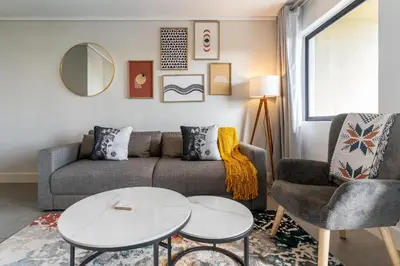a living room with a couch and a table at Waters Edge Apartments by Propr in Cape Town