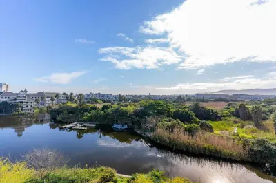 a river with boats in it in a city at Waters Edge Apartments by Propr in Cape Town