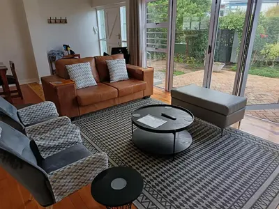 a living room with a couch and a coffee table at Rockwest 1 Cosy summer holiday house Hermanus in Hermanus