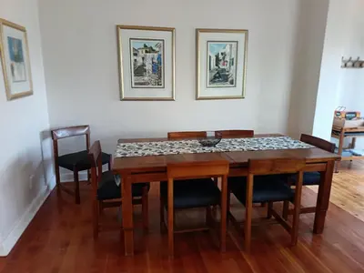 a dining room with a wooden table and chairs at Rockwest 1 Cosy summer holiday house Hermanus in Hermanus