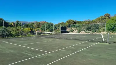 a tennis net on a tennis court at Beach House, Pool, Braai, Patio, Water Sports in Hermanus