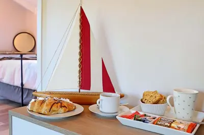 a table with a plate of food and a boat on it at Beach House, Pool, Braai, Patio, Water Sports in Hermanus