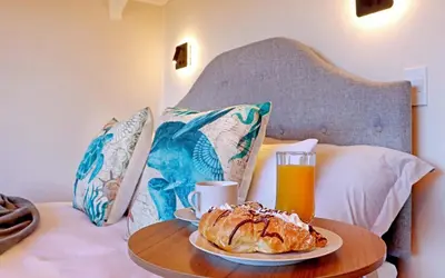 a table with a plate of pastry and a glass of orange juice at Beach House, Pool, Braai, Patio, Water Sports in Hermanus