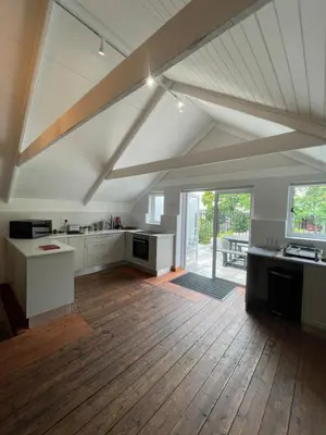 a large kitchen with white cabinets and a wooden floor at Stay At Nantes in Paarl