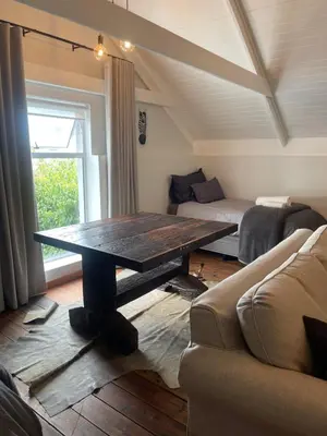 a living room with a wooden table and a couch at Stay At Nantes in Paarl