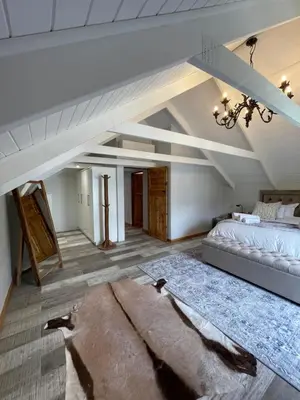 a attic bedroom with a bed and a couch at Stay At Nantes in Paarl