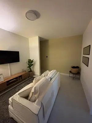 a living room with a white couch and a flat screen tv at Inside Out Bliss in Paarl