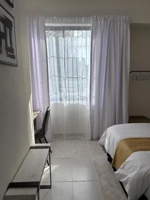 a bedroom with a bed and a window at Inside Out Bliss in Paarl