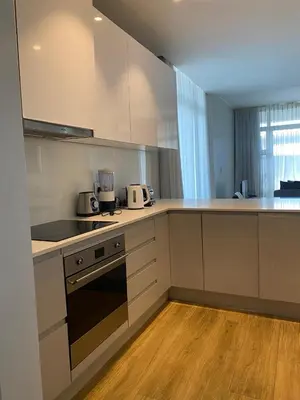 a kitchen with white cabinets and a stove top oven at Serene Global Capetown Axis in Cape Town