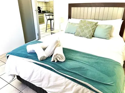 a bedroom with a bed with towels on it at Cosy Flatlet in Chrismar in Stikland