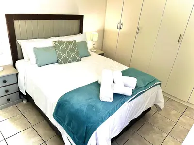 a bedroom with a bed with towels on it at Cosy Flatlet in Chrismar in Stikland