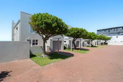 a row of trees in front of a building at Breakwater Nr 4 holiday apartment in Hermanus