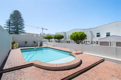 a swimming pool on top of a brick patio at Breakwater Nr 4 holiday apartment in Hermanus