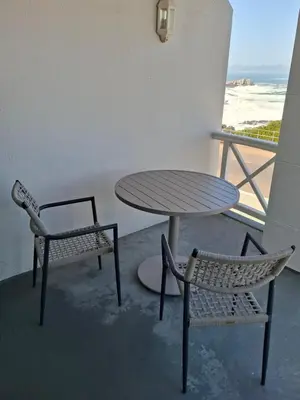 two chairs and a table and a table and chairs at Breakwater Nr 4 holiday apartment in Hermanus