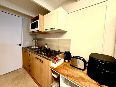 a kitchen with a counter with a stove and a microwave at Secure & Central, Modern Flatlet in Cape Town