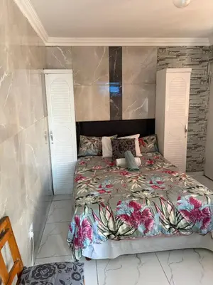 a bedroom with a bed with a floral bedspread at Browns villa and construction pty ltd in Cape Town