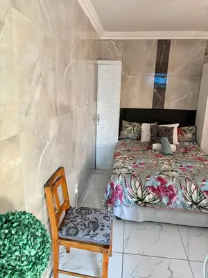a bedroom with a bed and a chair at Browns villa and construction pty ltd in Cape Town