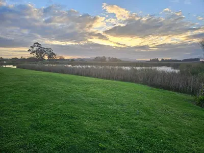 a grassy field with a lake in the background at Protea Rus in Wellington