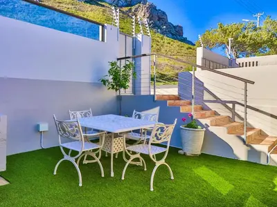 a patio with a table and chairs and stairs at Mountain Rest Hermanus in Hermanus