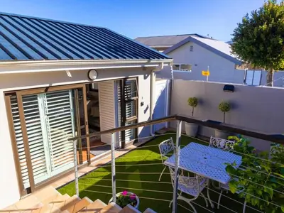 a balcony with a blue table and chairs at Mountain Rest Hermanus in Hermanus