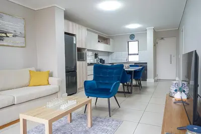 a living room with a couch and a table at Walk to Canal Walk - Modern Flat in Cape Town