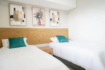 two beds sitting next to each other in a bedroom at Walk to Canal Walk - Modern Flat in Cape Town