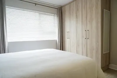 a bedroom with a white bed and a window at Walk to Canal Walk - Modern Flat in Cape Town