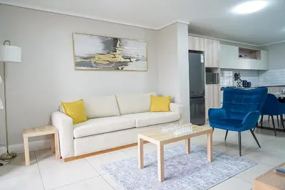 a living room with a couch and a table at Walk to Canal Walk - Modern Flat in Cape Town