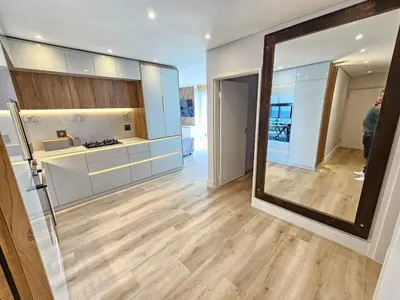 a large mirror in a room with a kitchen at Luxury Portico Apartment in Cape Town
