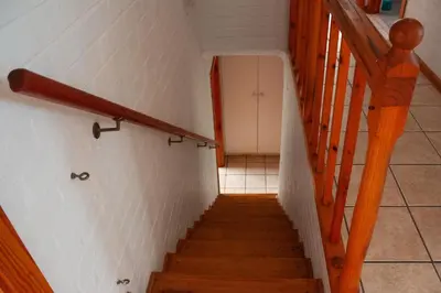 a staircase in a house with a stair railing at Yellowwood Place in Bettyʼs Bay