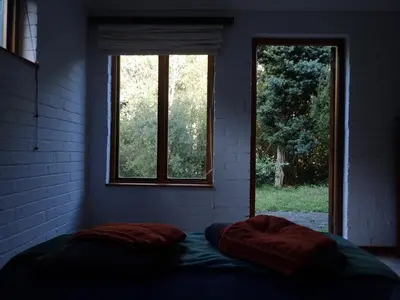 a bed in a room with two windows at Yellowwood Place in Bettyʼs Bay